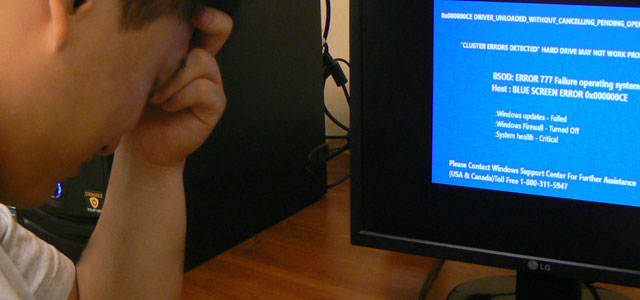 Photo showing a person in distress after computer screen turns blue due to hard drive failure.